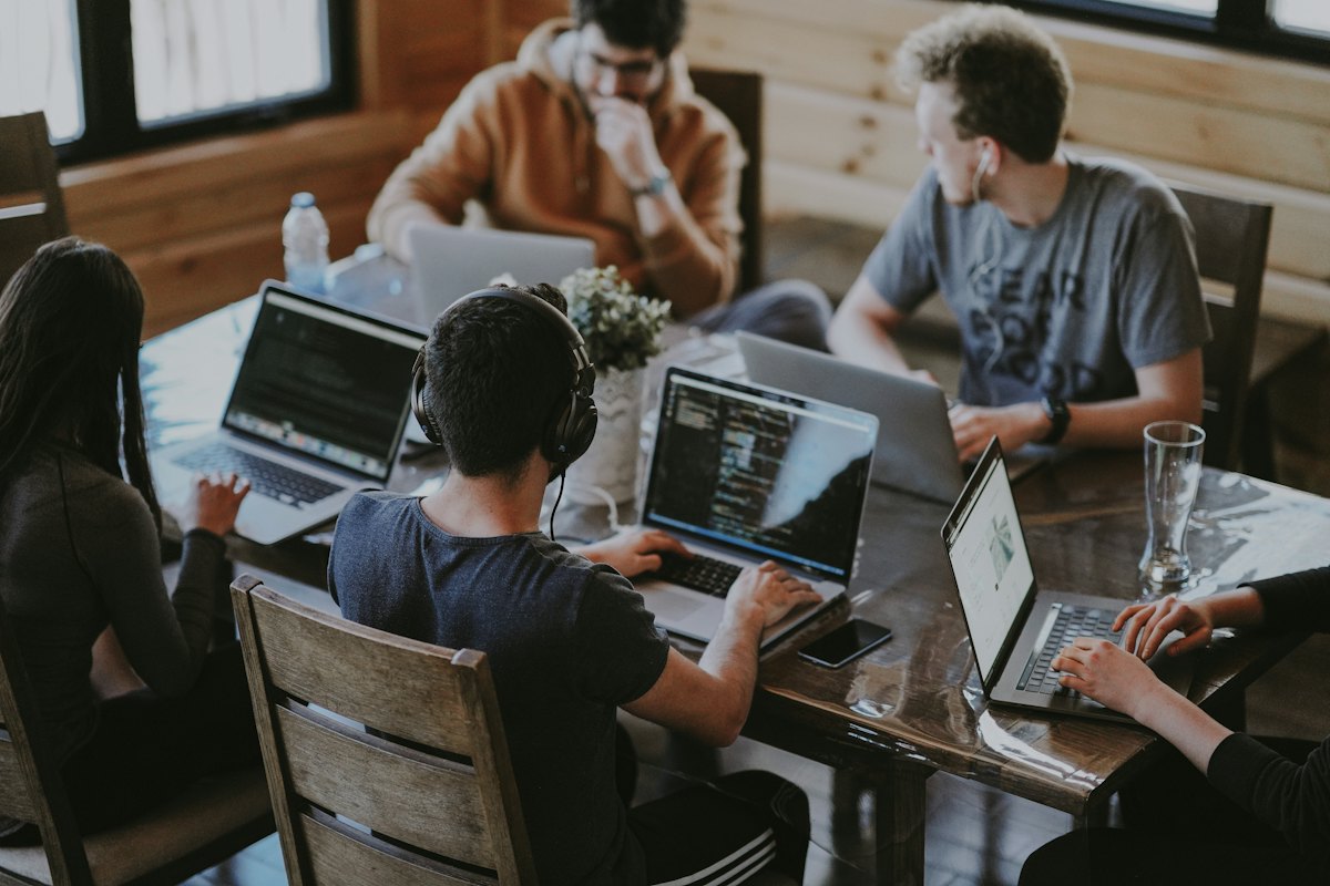 Consultants collaborating around a table with laptops